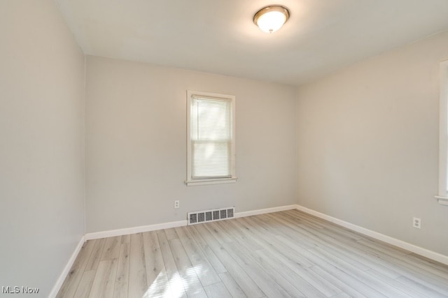 unfurnished room featuring visible vents, baseboards, and wood finished floors