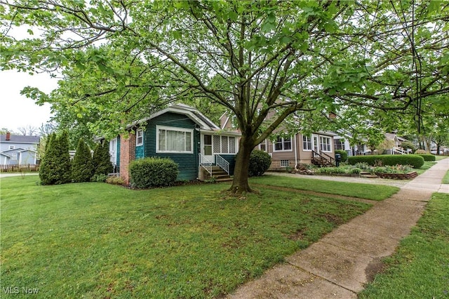 view of front of house with entry steps and a front yard
