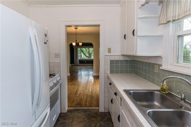 kitchen featuring open shelves, white appliances, tile counters, white cabinetry, and a sink