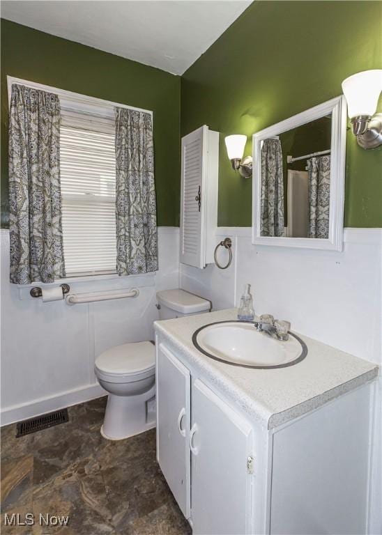 full bathroom featuring vanity, a shower with curtain, toilet, and visible vents