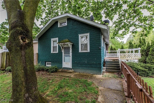 bungalow-style home featuring fence, stairs, and a deck