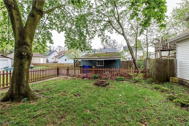 view of yard with a fenced backyard, an outbuilding, and a residential view