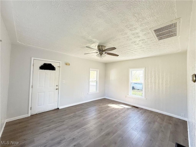 empty room featuring a ceiling fan, a textured ceiling, and visible vents