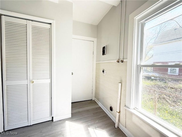 laundry room with electric dryer hookup, laundry area, wood finished floors, and a wealth of natural light