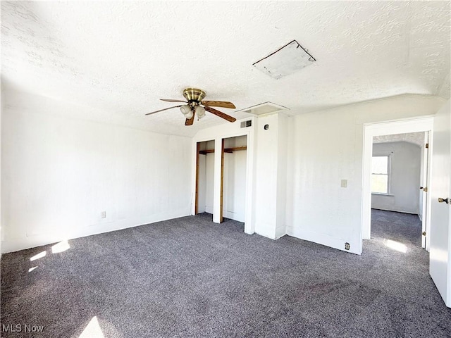 unfurnished bedroom featuring dark colored carpet, a ceiling fan, a textured ceiling, and visible vents