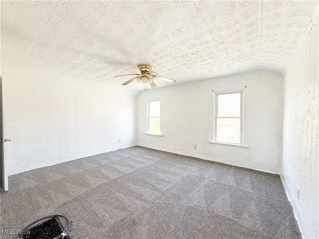 carpeted spare room with baseboards, a textured ceiling, and ceiling fan