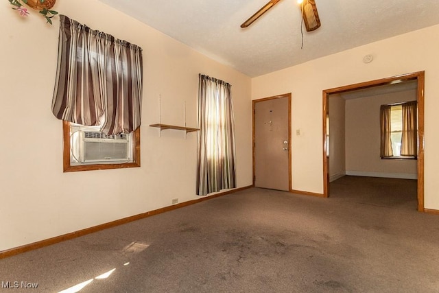 carpeted empty room with ceiling fan, baseboards, and cooling unit