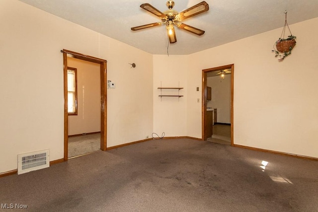 carpeted spare room featuring baseboards, a ceiling fan, and visible vents