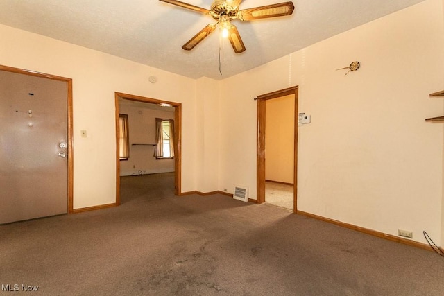 spare room with carpet floors, ceiling fan, baseboards, and visible vents