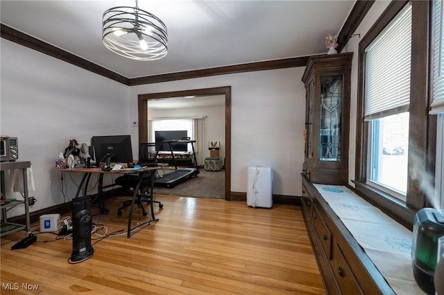 office space with baseboards, ornamental molding, and light wood-style flooring