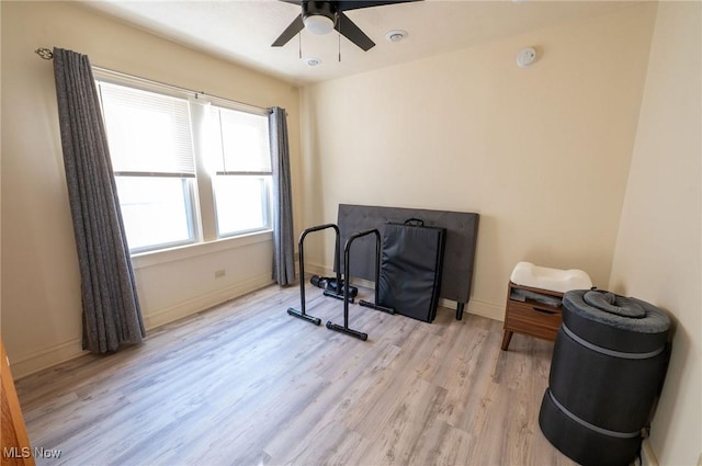 living area featuring ceiling fan, baseboards, and light wood-type flooring