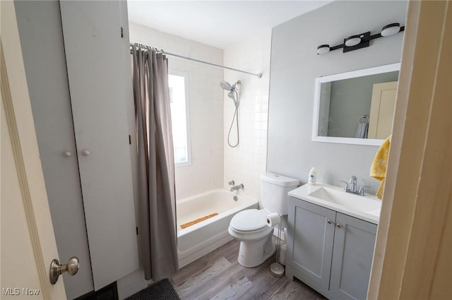 full bathroom featuring vanity, wood finished floors, shower / bath combo, and toilet