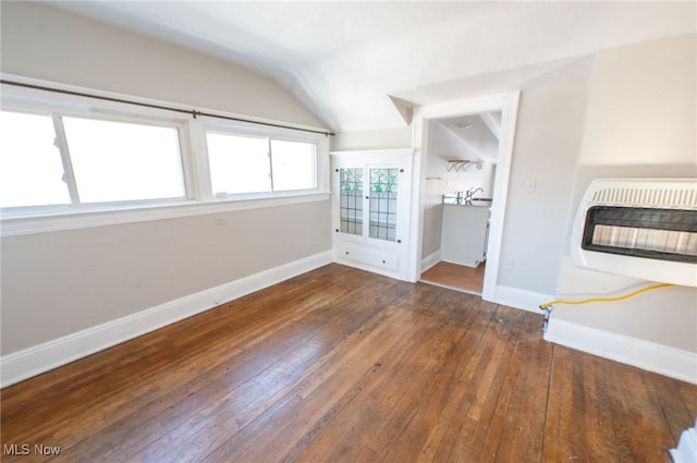 unfurnished living room featuring heating unit, baseboards, hardwood / wood-style flooring, and lofted ceiling