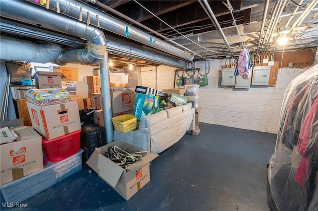 unfinished basement featuring concrete block wall and electric panel