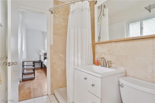 full bath with vanity, toilet, tile patterned floors, tile walls, and a shower with curtain