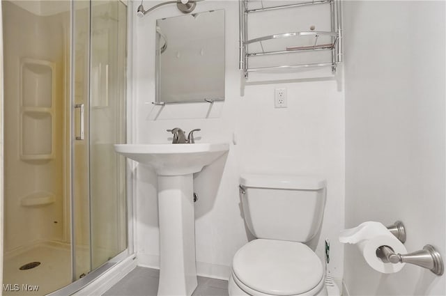 full bath featuring tile patterned floors, baseboards, a stall shower, and toilet