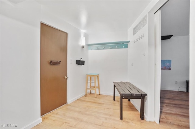 hall with baseboards and wood finished floors