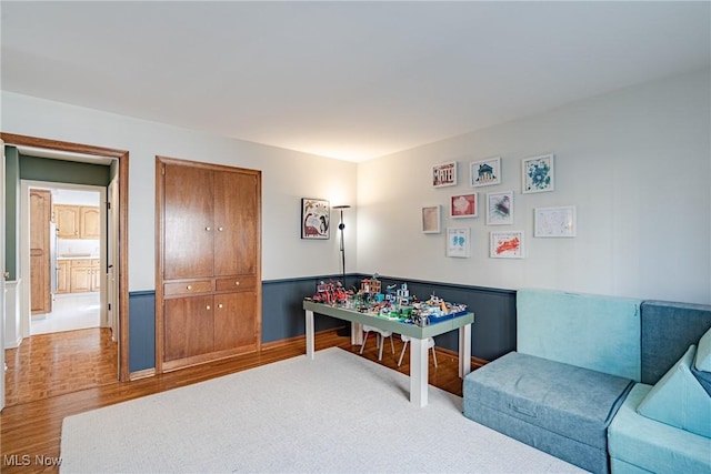 playroom featuring wood finished floors and a wainscoted wall