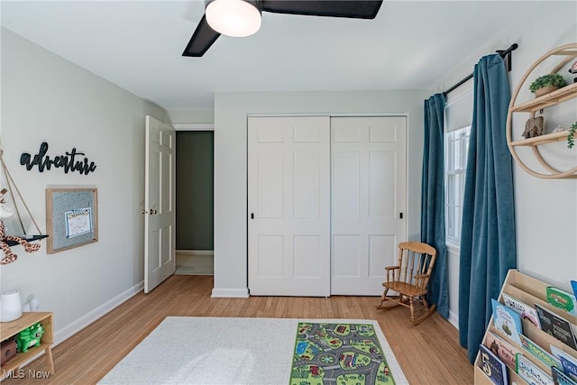 living area featuring baseboards, ceiling fan, and wood finished floors