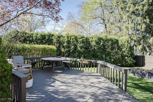 wooden deck with fence, outdoor dining space, and a yard