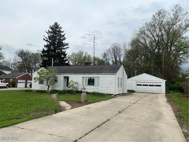view of front of property with a chimney, an outbuilding, a front lawn, and a garage