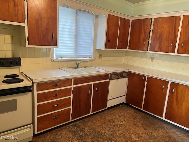 kitchen featuring a sink, backsplash, white appliances, and light countertops