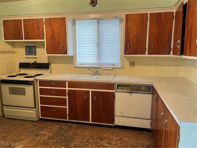kitchen featuring brown cabinets, a sink, white appliances, light countertops, and decorative backsplash
