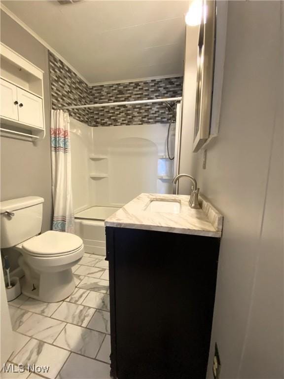 full bath featuring vanity, ornamental molding, marble finish floor, shower / bath combo with shower curtain, and toilet