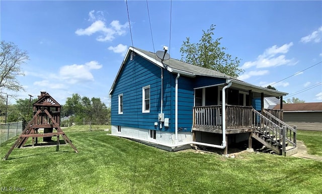 rear view of house with a yard, fence, and a wooden deck