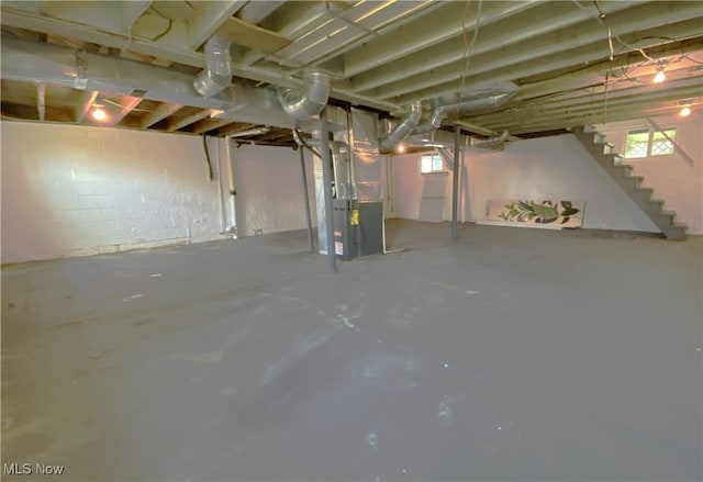 basement featuring heating unit and stairs