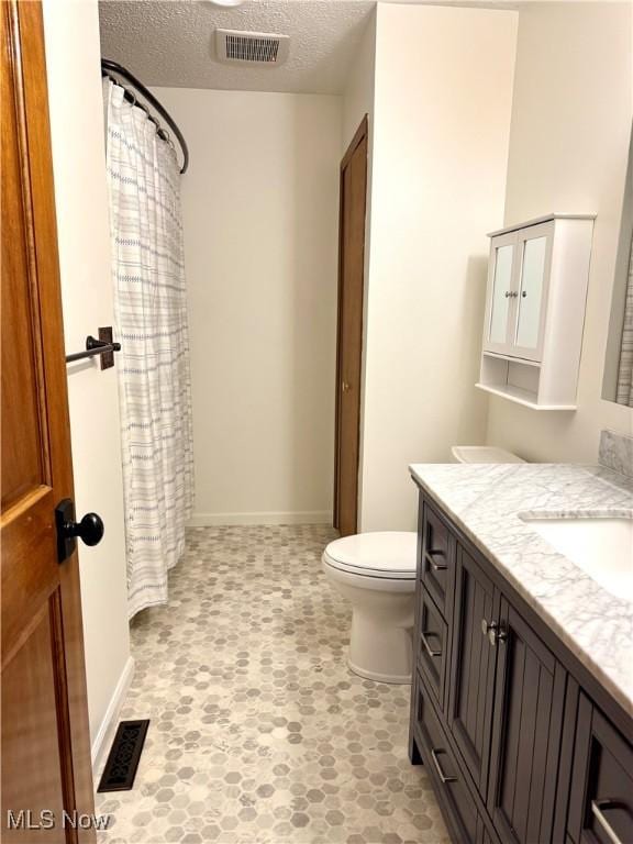 full bath with toilet, a textured ceiling, visible vents, and vanity