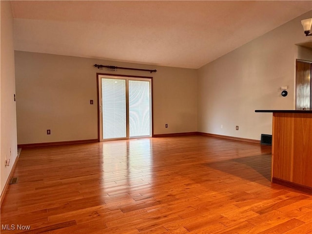 unfurnished living room featuring light wood-type flooring, baseboards, and visible vents