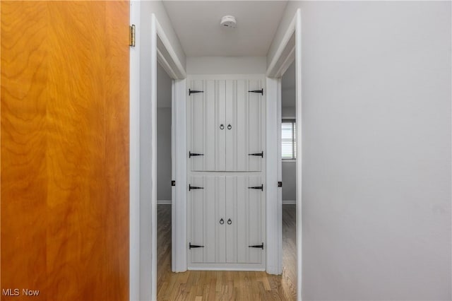 hallway with baseboards and light wood finished floors