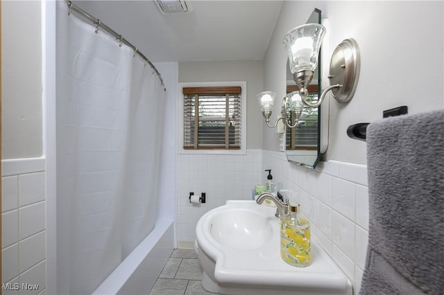 bathroom featuring visible vents, tile walls, tile patterned flooring, a sink, and a wainscoted wall