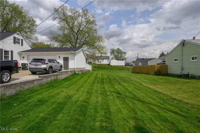 view of yard with fence, cooling unit, and driveway