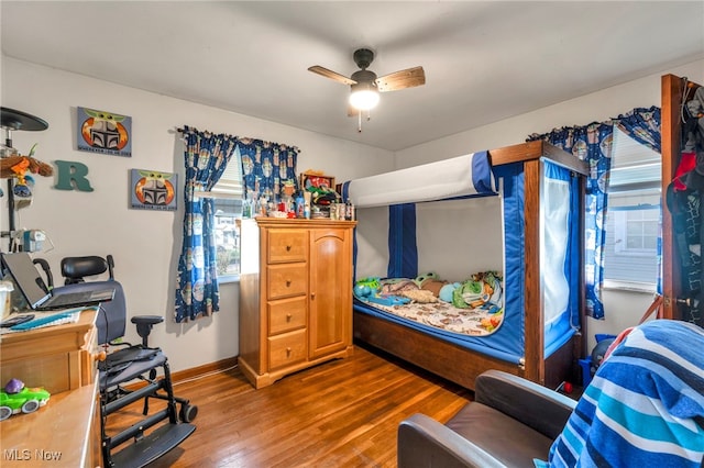 bedroom with baseboards, a ceiling fan, and wood finished floors