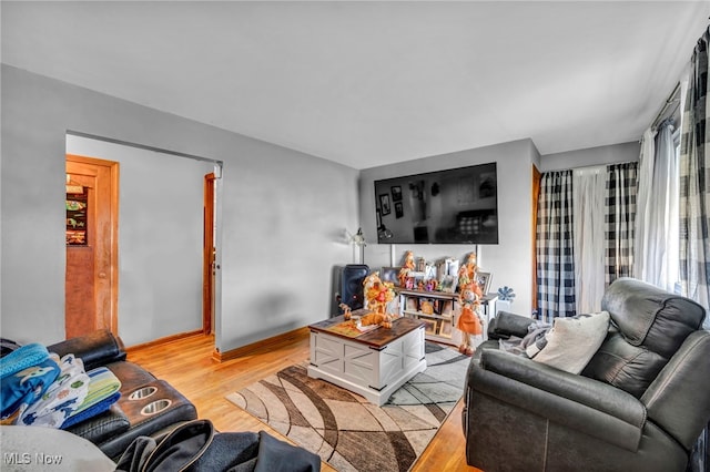living room featuring baseboards and light wood-type flooring