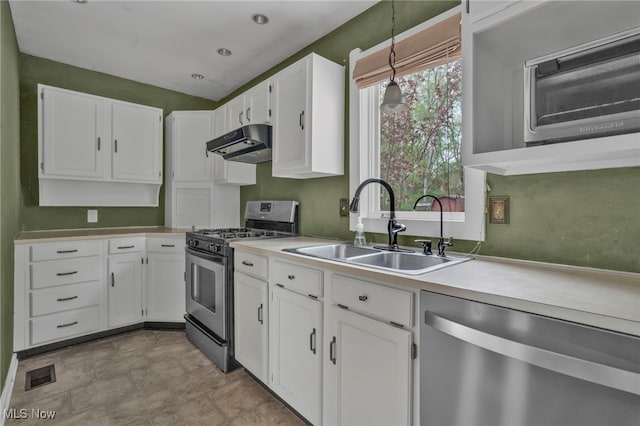 kitchen with visible vents, under cabinet range hood, white cabinets, a sink, and stainless steel appliances
