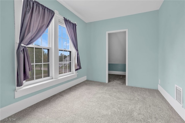 carpeted empty room with visible vents and baseboards