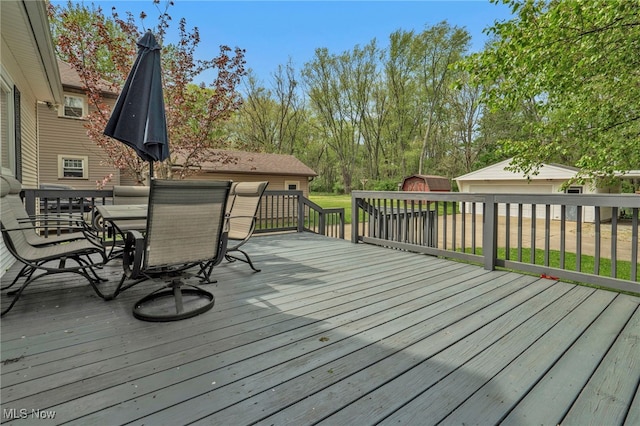 deck featuring a storage shed, an outdoor structure, and outdoor dining space