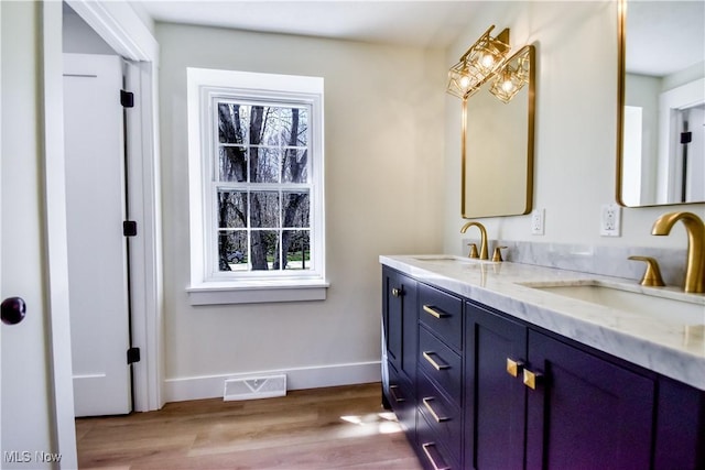 full bath featuring a sink, baseboards, wood finished floors, and visible vents