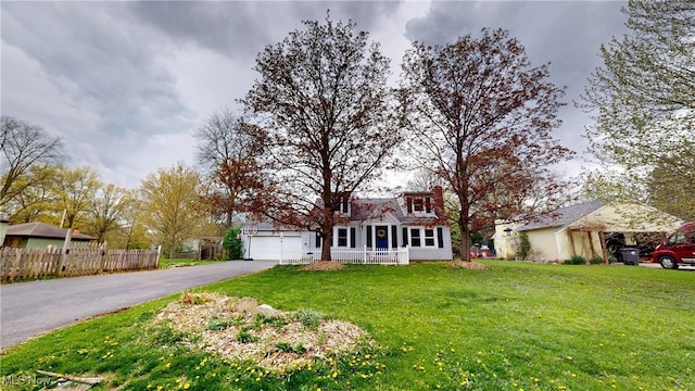 view of front of home featuring fence, a garage, driveway, and a front lawn
