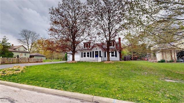 cape cod home with fence, an attached garage, a front lawn, a porch, and driveway