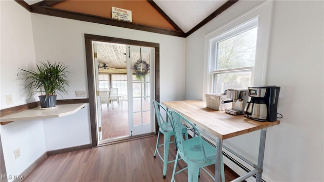 dining space with plenty of natural light, wood finished floors, and lofted ceiling