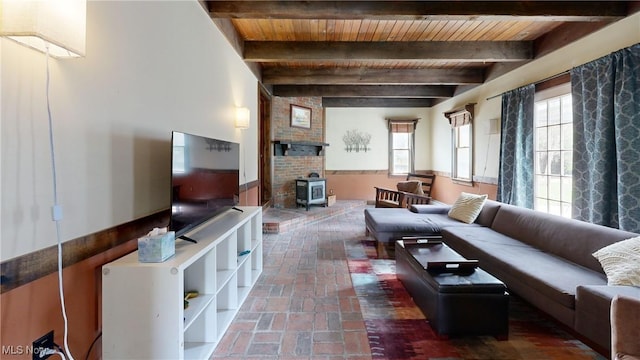 living room featuring a wood stove, brick floor, wooden ceiling, and beamed ceiling