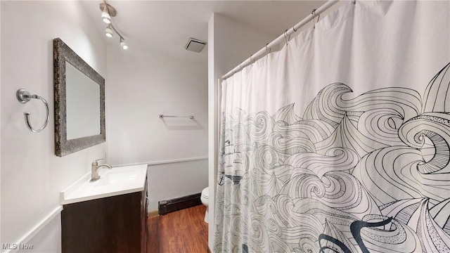 full bath with visible vents, wood finished floors, vanity, a baseboard radiator, and toilet