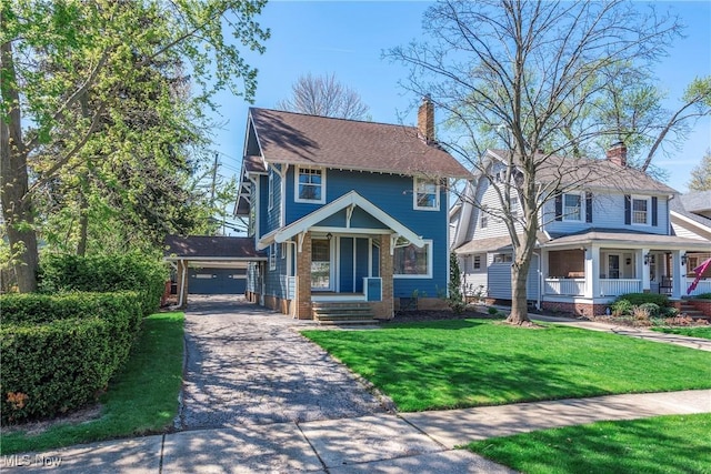 view of front of home featuring covered porch, a chimney, and a front yard