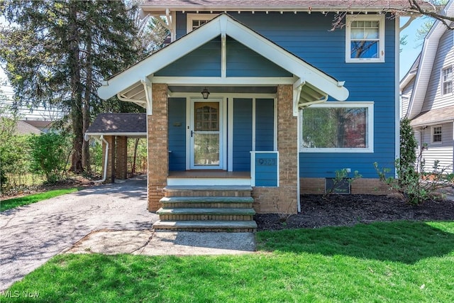 view of front of house with covered porch, a front yard, and aphalt driveway