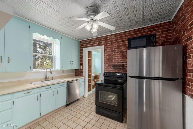 kitchen with light countertops, brick wall, a sink, and black appliances