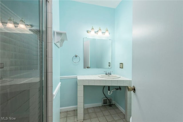 full bathroom featuring visible vents, tile patterned flooring, baseboards, a sink, and a stall shower